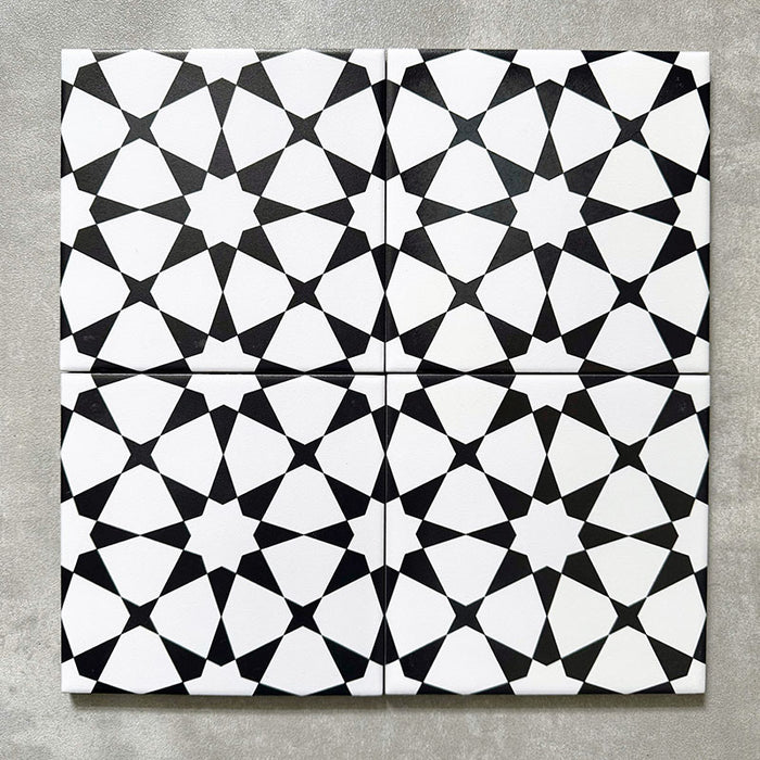 Agadir Black & White Mini Moroccan-style 15x15cm porcelain tiles arranged as four tiles, showcasing a repeating geometric star pattern in black and white on a neutral background.