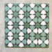 Four Agadir Verde Moroccan-style 20x20cm porcelain tiles laid together, forming a continuous geometric star pattern in soft green, white and charcoal tones.