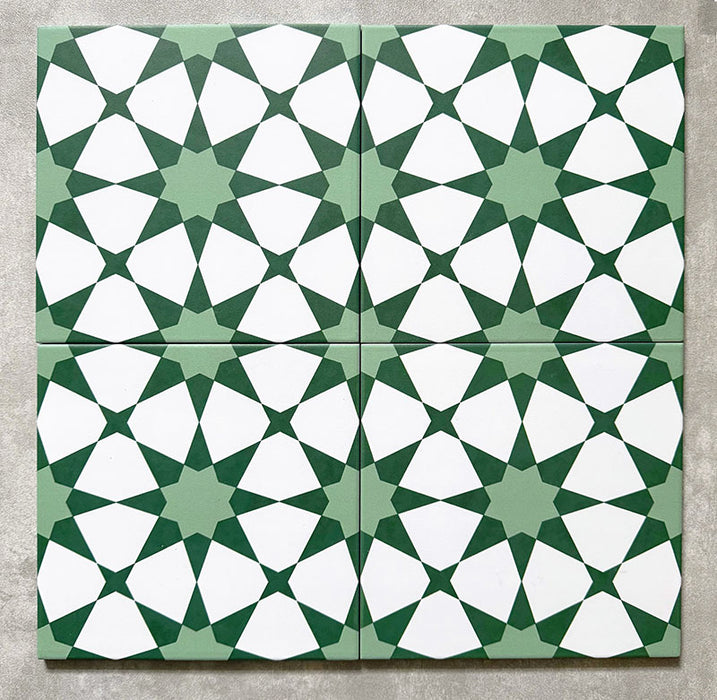 Agadir Green Moroccan-style 20x20cm porcelain tiles arranged as four tiles, showcasing a repeating geometric star pattern in green and white on a neutral background.