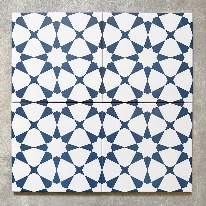 Agadir Navy Blue Moroccan-style 20x20cm porcelain tiles arranged as four tiles, showcasing a repeating geometric star pattern in navy and white on a neutral background.