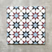 Agadir Atlas Mini Moroccan-style 15x15cm porcelain tiles arranged as four tiles, showcasing a repeating geometric star pattern in soft blue, burgundy, black and cream on a neutral background.