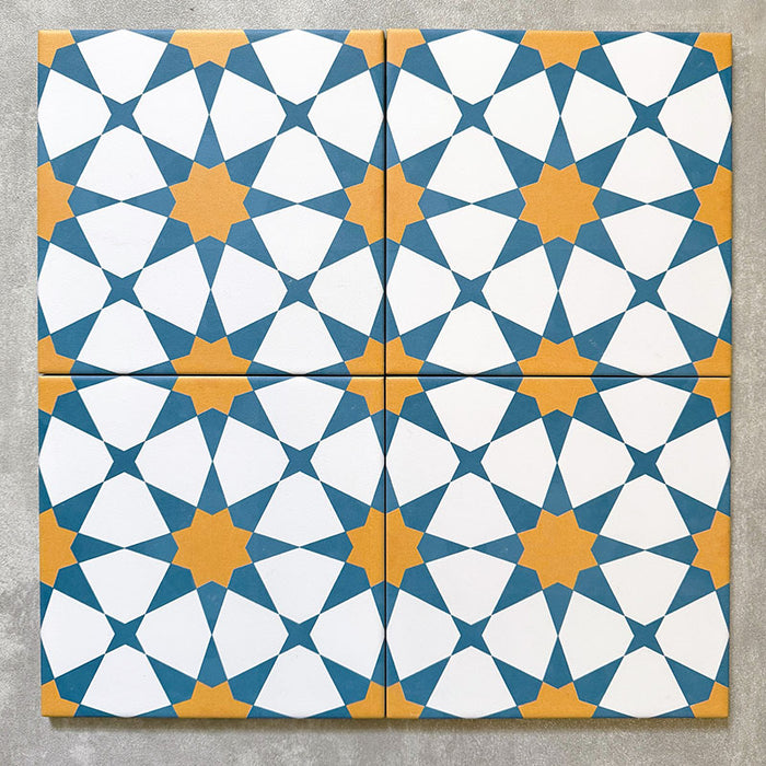 Agadir Sun and Sky Moroccan-style 20x20cm porcelain tiles arranged as four tiles, showcasing a repeating geometric star pattern in blue, white and warm yellow on a neutral background.