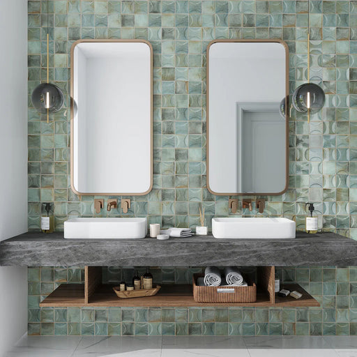 Bathroom featuring Saigon Celadon Green Decor Square Wall tiles in a Moroccan-inspired style, 10 × 10cm glossy ceramic tiles in soft green and blue tones with a decorative relief pattern, paired with a double vanity and wall-mounted mirrors.