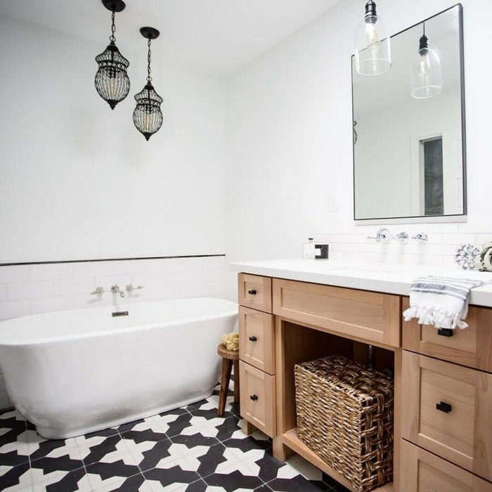 Bathroom featuring Almeria Cathedral Moroccan-style porcelain floor tiles in a bold black and white geometric pattern, 20x20cm, paired with light wood vanity units and white wall tiles.
