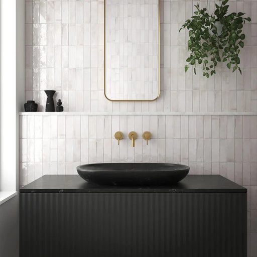 Bathroom wall featuring Saigon White Brick Wall tiles in a Moroccan-inspired style, 5.1 × 16.1cm glossy ceramic tiles in soft white tones, paired with a black vanity, brass fittings, and a minimalist mirror.