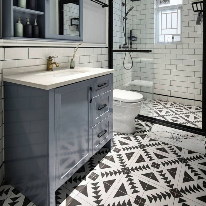 Almeira Azteca Moroccan-style porcelain floor tiles in a modern bathroom, featuring a bold black and white geometric triangle pattern paired with white metro wall tiles, 20x20cm.