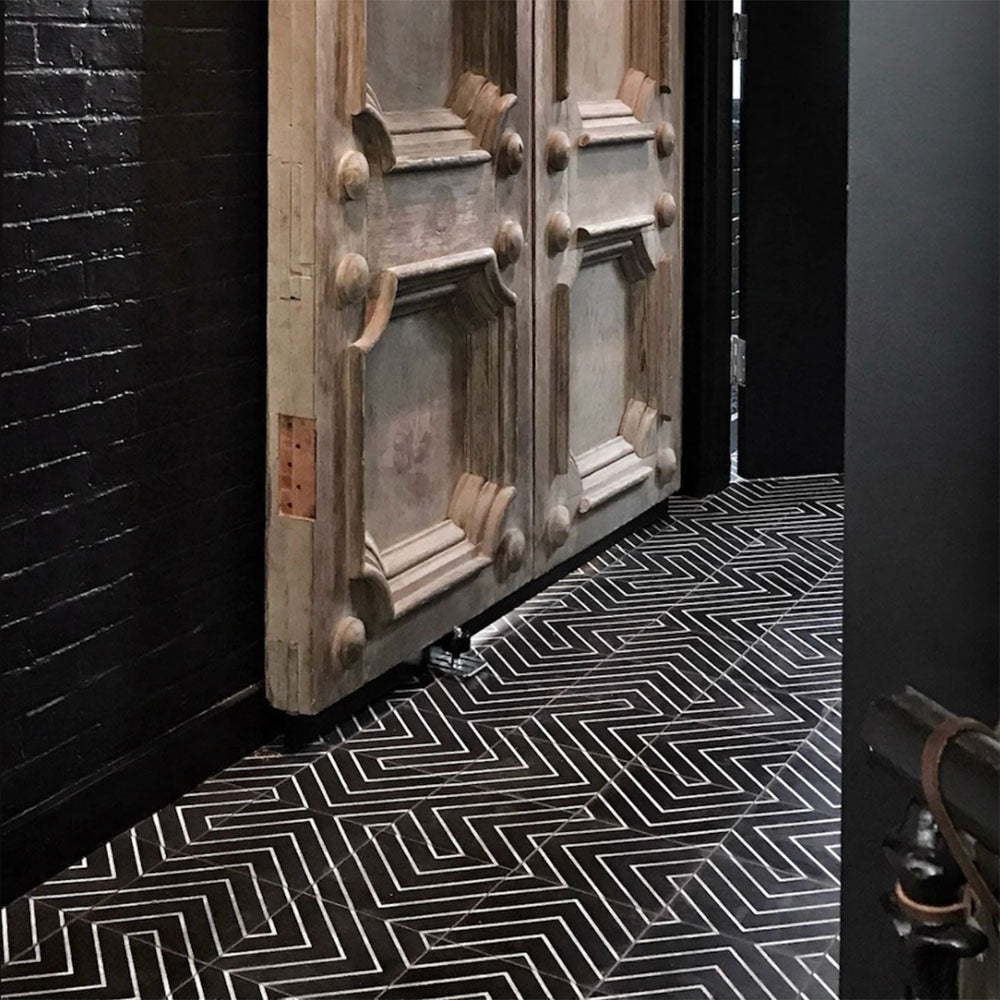 Hallway floor featuring Almeria Jilani Black Moroccan-style porcelain tiles in a striking white line geometric chevron pattern, 20x20cm, creating a bold and contemporary walkway.
