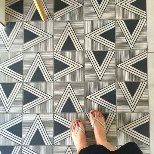 Floor featuring Almeria Giza Moroccan-style porcelain tiles in a bold black and white geometric triangle pattern, 20x20cm, creating a striking and contemporary tiled surface.