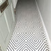 Hallway floor featuring Almeria Jilani White Moroccan-style porcelain tiles in a bold black line geometric diamond pattern, 20x20cm, creating a striking monochrome walkway.