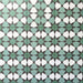 Group of Agadir Verde Moroccan-style 20x20cm porcelain tiles laid together, showcasing a repeating geometric star pattern in green, white and charcoal tones.
