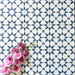 Agadir Navy Blue Moroccan-style 20x20cm porcelain floor tiles laid in a repeating geometric star pattern in navy and white, styled with a decorative orchid to highlight the intricate design.