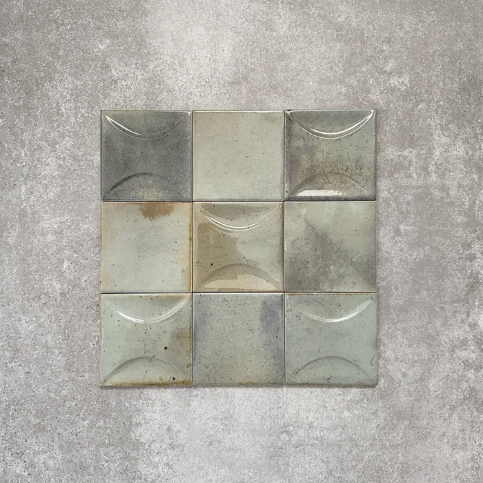 Close-up of Saigon Celadon Green Decor Square Wall tiles, featuring Moroccan-style 10 × 10cm glossy ceramic tiles in soft green and blue-grey tones with a curved decorative relief pattern.