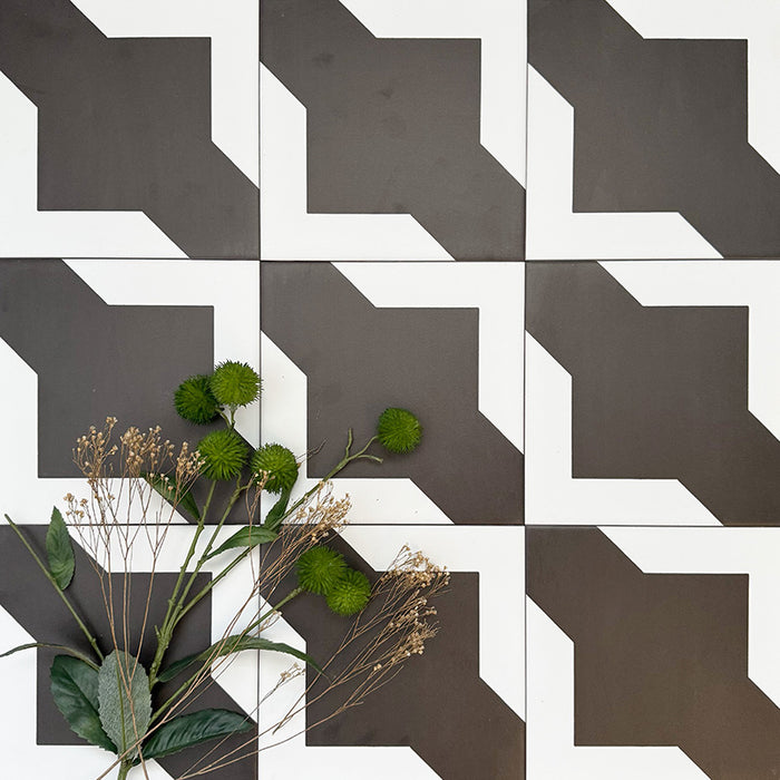 Almeria Cathedral Moroccan-style porcelain wall and floor tiles arranged in a repeating black and white geometric pattern, 20x20cm, styled with greenery for a decorative display.