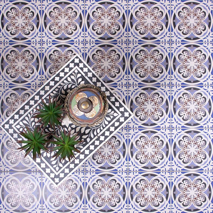 Living space styled with Imperial Victorian Blue Mini Tiles, 15x15cm porcelain tiles featuring a classic Victorian-inspired pattern in soft blue and grey tones, arranged as a decorative floor design with plants and accessories.