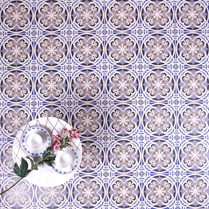 Patterned surface featuring Imperial Victorian Blue Mini Tiles, 15x15cm porcelain tiles with a classic Victorian-inspired design in soft blue, grey, and white tones, styled with decorative tableware and flowers.