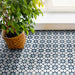 Living space featuring Agadir Azul Blue Moroccan-style 20x20cm porcelain floor tiles, showcasing a geometric star pattern in blue and white, styled with natural light and a potted plant for a fresh, modern look.
