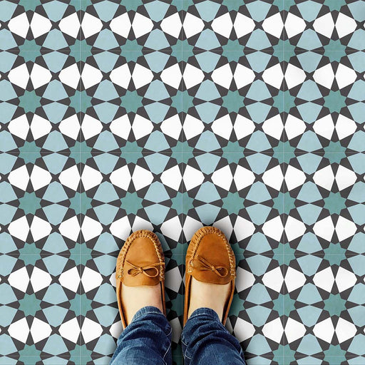 Marketing image featuring Agadir Verde Moroccan-style 20x20cm porcelain floor tiles laid in a repeating geometric star pattern in green, white and charcoal tones, styled with shoes to highlight scale, durability and everyday use.