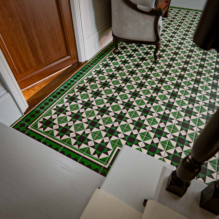 Greenbrook Manor anti-slip encaustic Victorian-style porcelain tiles laid in a traditional hallway, featuring a repeating geometric pattern in green, black and white with a decorative border framing the floor.