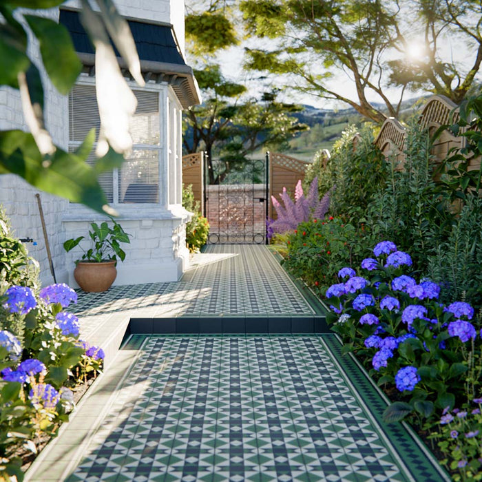 Outdoor garden path and steps finished with Greenbrook Manor anti-slip encaustic Victorian-style porcelain tiles, featuring a classic green, black and white geometric pattern framed by decorative borders and surrounded by planting.