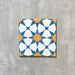 Agadir Sun and Sky Moroccan-style 20x20cm porcelain tile featuring a geometric star pattern in blue, white and warm yellow, shown as a single tile on a neutral background.