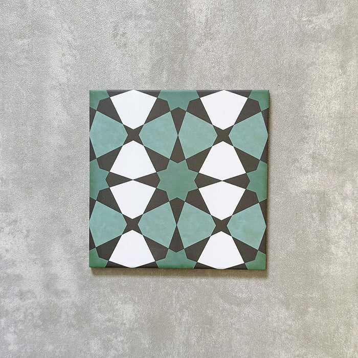 Single Agadir Verde Moroccan-style 20x20cm porcelain tile shown against a neutral background, featuring a geometric star pattern in green, white and charcoal tones.