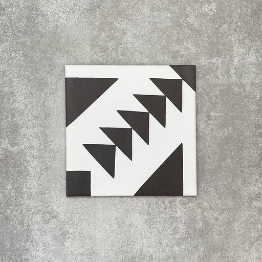 Single Almeira Azteca Moroccan-style porcelain tile featuring a bold black and white geometric triangle pattern, shown individually on a neutral background, 20x20cm.
