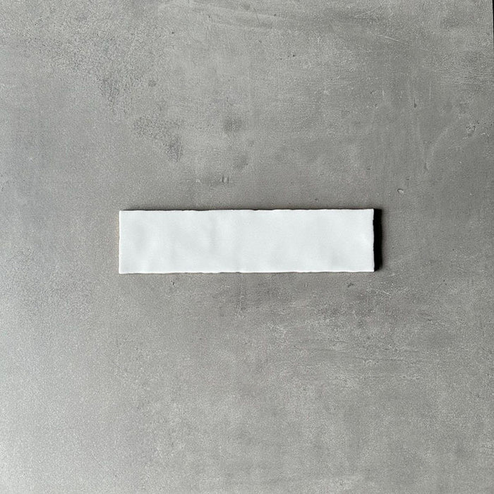 Single Nairobi gloss white handmade-effect tile shown close up, highlighting the softly uneven edges and subtle surface texture against a neutral background.