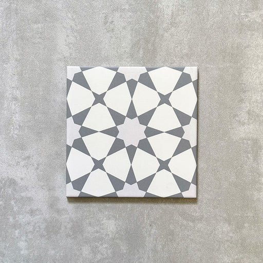 Single Agadir Silver Moroccan-style 20x20cm porcelain tile, featuring a geometric star pattern in soft silver and white tones on a neutral background.