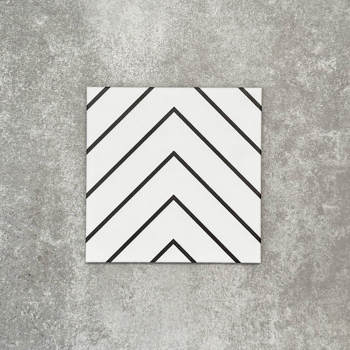 Single Almeria Jilani White Moroccan-style porcelain tile featuring a clean black line chevron pattern on a white base, 20x20cm, suitable for wall and floor use.
