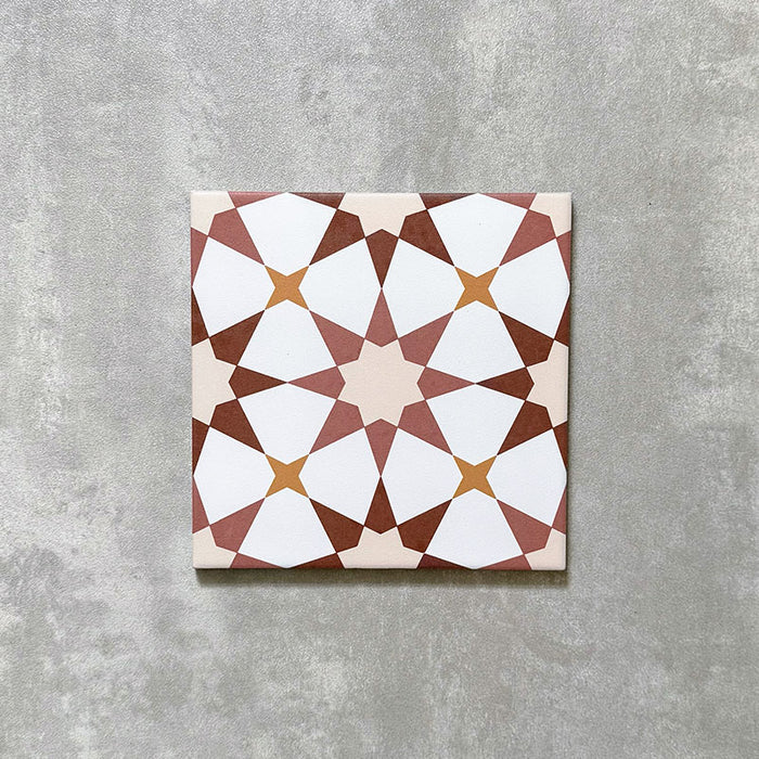 Agadir Cotto Moroccan-style 20x20cm porcelain tile featuring a geometric star pattern in warm terracotta, white and soft yellow tones, shown as a single tile on a neutral background.