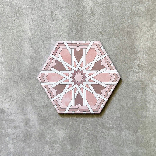 Single Medina Hormuz Rose Moroccan-style hexagon porcelain tile, 18.7 × 21.6 cm, featuring a bold star-inspired geometric pattern in soft rose and white tones on a neutral background.