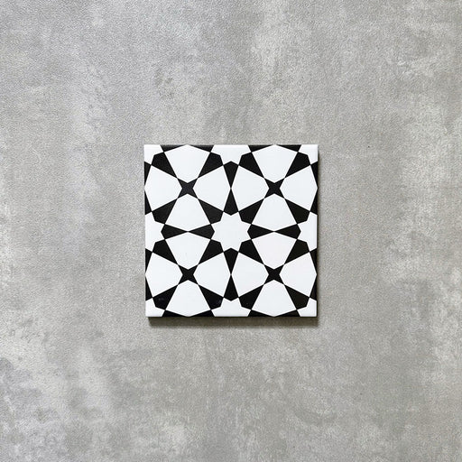 Agadir Black & White Mini Moroccan-style 15x15cm porcelain tile featuring a bold geometric star pattern in black and white, shown as a single tile on a neutral background.