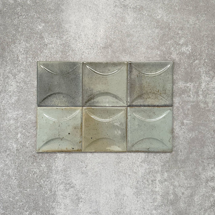 Close-up of Saigon Celadon Green Decor Square Wall tiles, featuring Moroccan-style 10 × 10cm glossy ceramic tiles in soft green and blue-grey tones with a curved decorative relief pattern.