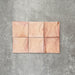 Close-up of Saigon Rose Pink Decor Square Wall tiles, featuring Moroccan-style 10 × 10cm glossy ceramic tiles in soft blush and rose tones with a curved decorative relief pattern.
