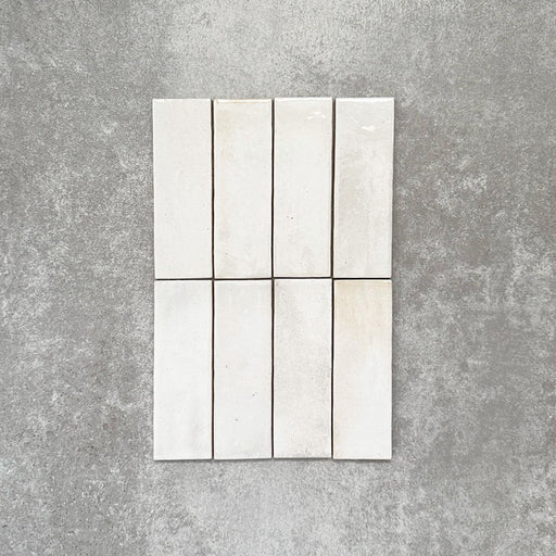 Close-up of Saigon White Brick Wall tiles in a Moroccan-style design, 5.1 × 16.1cm glossy ceramic tiles in soft white tones with subtle tonal variation, shown laid vertically.
