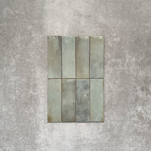 Close-up of Saigon Celadon Green Brick Wall tiles in a Moroccan-style design, 5.1 × 16.1cm glossy ceramic tiles with soft green and blue tonal variations, shown laid vertically.