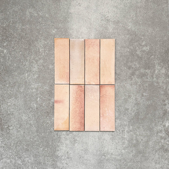 Close-up of Saigon Rose Pink Brick Wall tiles in a Moroccan-style design, 5.1 × 16.1cm glossy ceramic tiles with soft blush and rose colour variation, shown laid vertically.